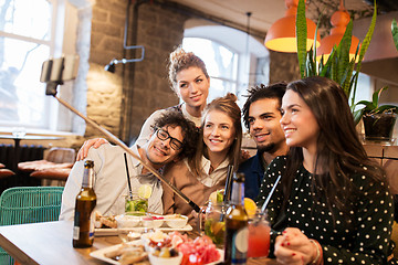 Image showing friends taking selfie by smartphone at bar or cafe