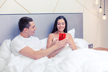 Image showing man giving woman little red gift box