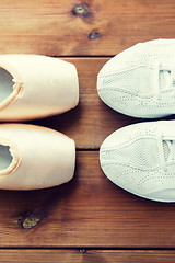 Image showing close up of sneakers and pointe shoes on wood