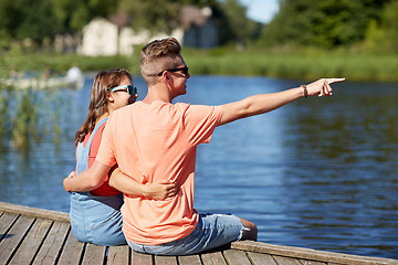 Image showing happy couple pointing finger on summer river berth