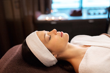 Image showing young woman with headband lying in spa parlor