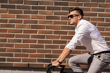 Image showing young man riding bicycle on city street