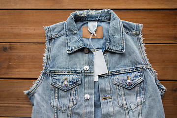 Image showing close up of denim waistcoat with price tag on wood