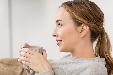 Image showing happy woman with cup or mug drinking at home