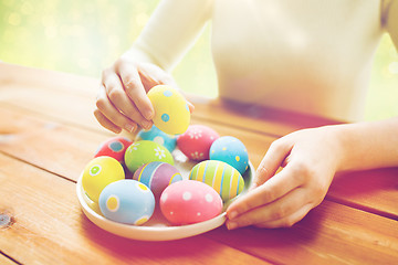 Image showing close up of woman hands with colored easter eggs