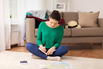 Image showing woman with notebook and travel map at home