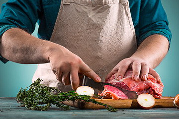 Image showing Butcher cutting pork meat on kitchen