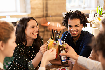 Image showing happy friends clinking drinks at bar or cafe