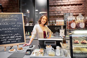 Image showing happy woman or barmaid at cafe counter