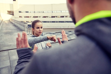 Image showing woman with trainer working out self defense strike