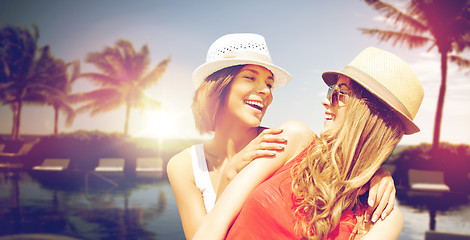 Image showing smiling young women in hats on beach