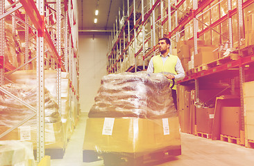 Image showing man carrying loader with goods at warehouse