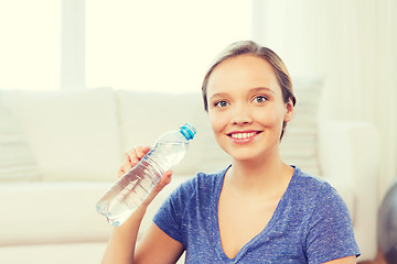 Image showing happy woman with water bottle at home