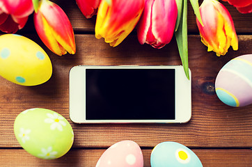 Image showing close up of easter eggs, flowers and smartphone