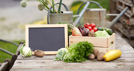 Image showing close up of vegetables with chalkboard on farm