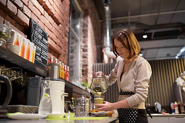 Image showing woman or barmaid cooking smoothie at vegan cafe