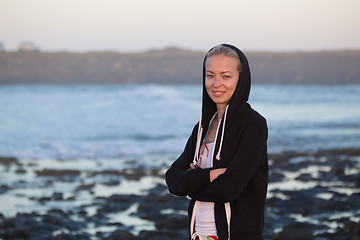 Image showing Sporty woman on sandy beach at dusk.