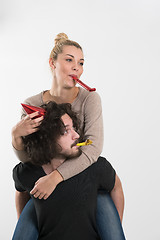 Image showing couple in party hats blowing in whistle