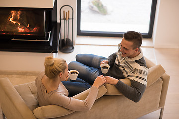 Image showing Young couple  in front of fireplace