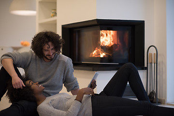 Image showing multiethnic couple used tablet computer on the floor