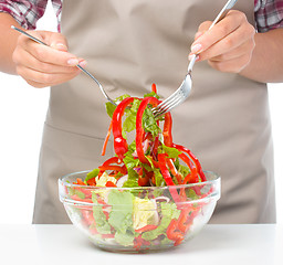 Image showing Cook is mixing salad