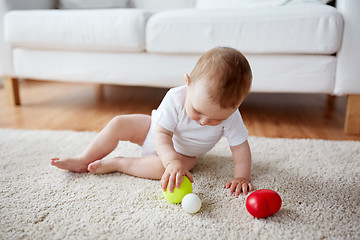 Image showing happy baby playing with balls on floor at home