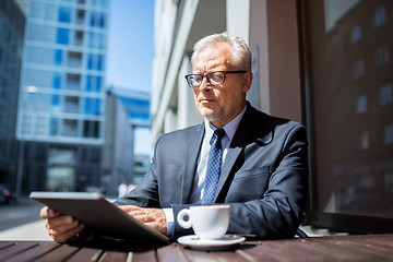 Image showing senior businessman with tablet pc drinking coffee