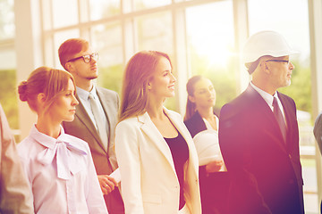 Image showing business team in helmets walking along office