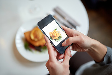 Image showing woman with smartphone photographing food at cafe