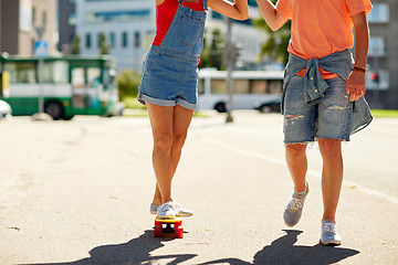 Image showing teenage couple riding skateboard on city street