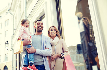 Image showing happy family with child and shopping bags in city