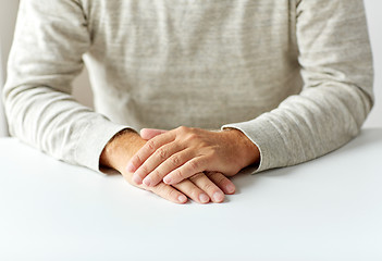 Image showing close up of senior man hands on table