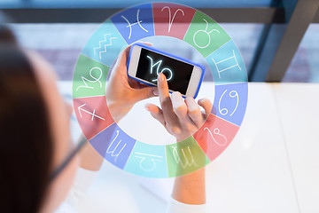 Image showing woman with smartphone and zodiac signs at office