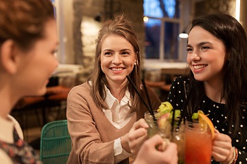 Image showing happy friends clinking drinks at restaurant