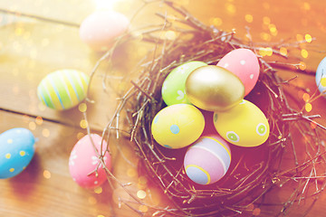 Image showing close up of colored easter eggs in nest on wood