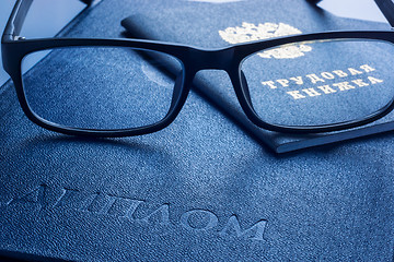 Image showing Glasses on diploma of higher education and employment history book