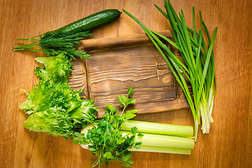 Image showing Fresh greens and rustic wooden dish