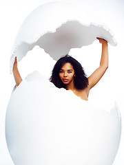 Image showing young pretty african american woman in big cracked egg isolated on white background, fashion people concept 