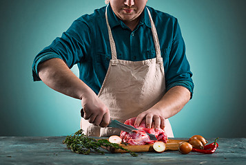 Image showing Butcher cutting pork meat on kitchen