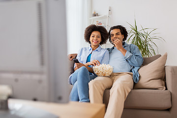 Image showing smiling couple with popcorn watching tv at home