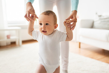 Image showing happy baby learning to walk with mother help