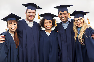 Image showing happy students or bachelors in mortar boards