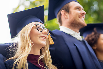 Image showing happy students or bachelors in mortar boards