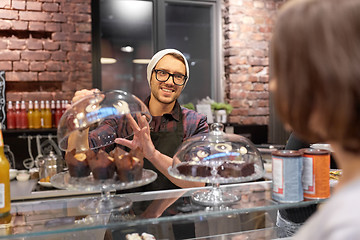 Image showing man or barman with cakes serving customer at cafe