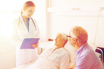 Image showing senior woman and doctor with clipboard at hospital