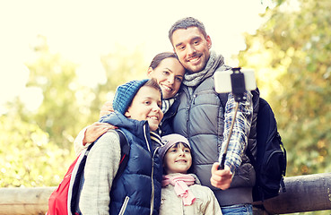 Image showing happy family with smartphone selfie stick in woods