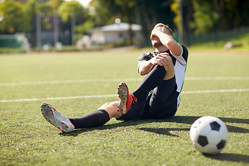 Image showing injured soccer player with ball on football field