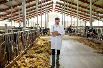 Image showing veterinarian with cows in cowshed on dairy farm