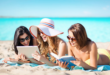 Image showing women with tablet pc and book on summer beach