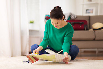 Image showing woman with notebook and travel map at home
